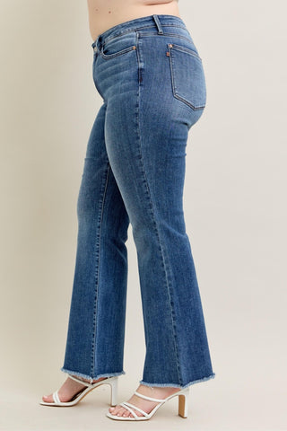 Blue jeans worn by a person on a plain background