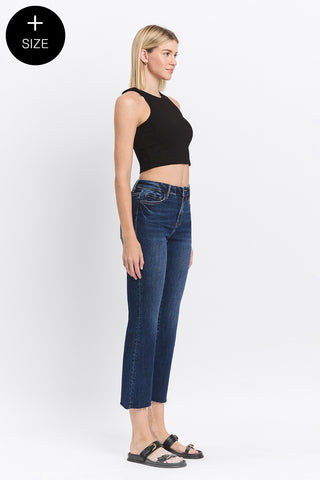 Woman wearing blue jeans and a black top on a white background