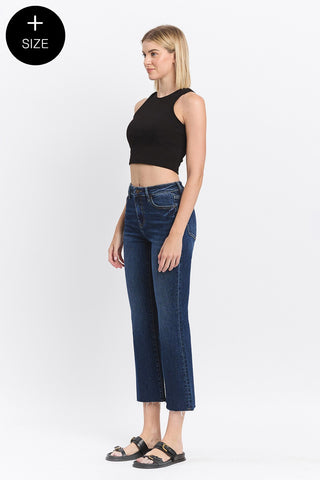Woman wearing blue jeans and a black top on a white background