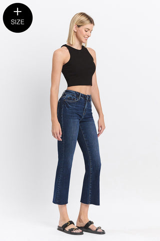 Woman wearing blue jeans and a black top on a white background