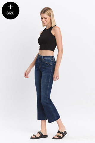 Woman wearing blue jeans and a black top on a white background