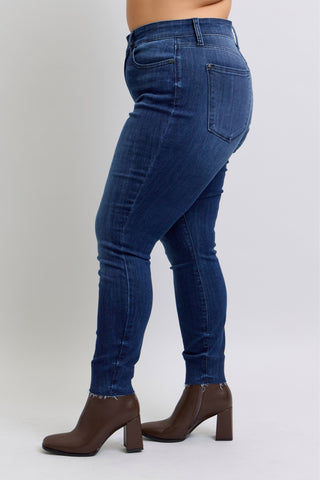 Person wearing blue jeans and brown boots on a white background