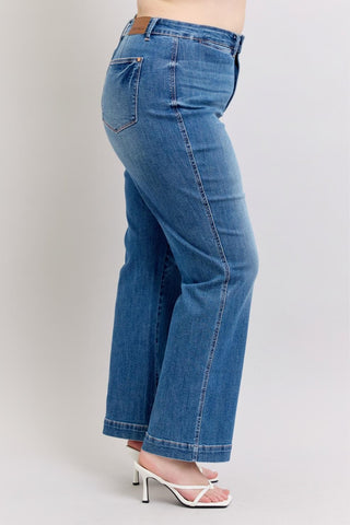 Blue jeans worn by a person on a plain background