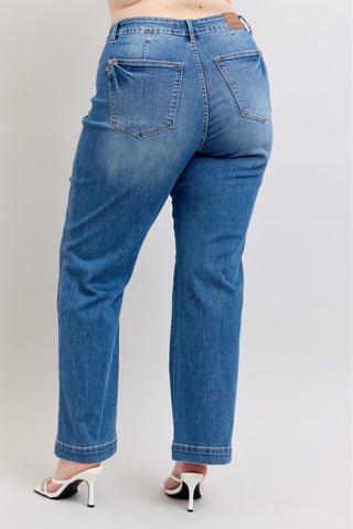 Blue jeans worn by a person on a plain background