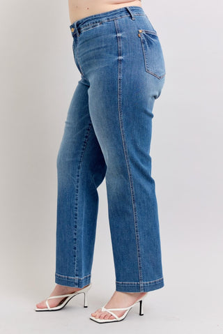 Blue jeans worn by a person on a plain background