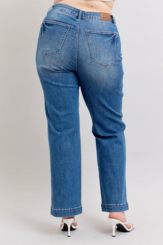 Blue jeans worn by a person on a plain background