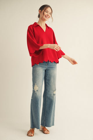 Woman wearing a red blouse and blue jeans on a beige background