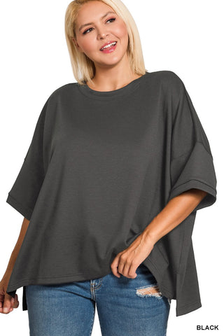 Woman wearing a dark gray oversized t-shirt and blue jeans on a white background