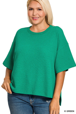 Woman wearing a green sweater and blue jeans on a white background