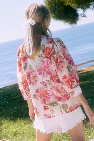 Woman wearing a floral kimono by a body of water