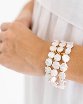 Pearl bracelet on a person's wrist with a white background