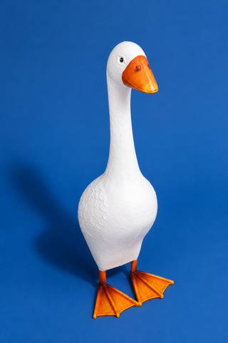White goose figurine with orange feet and beak on a blue background