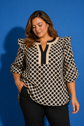 Woman wearing a polka dot blouse against a blue background