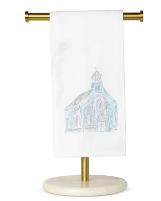 Towel with a church design on a gold towel rack against a white background