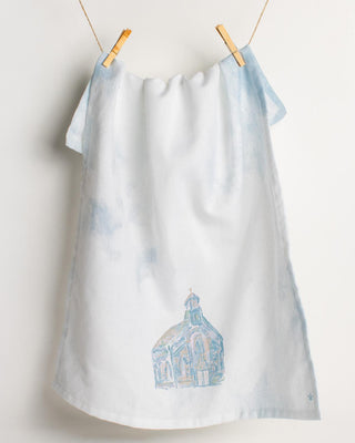 White towel with blue design hanging on a clothesline against a white background