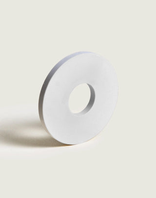 White circular object with a central hole on a light gray background