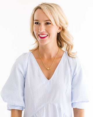 Woman wearing a light blue striped shirt with a white background