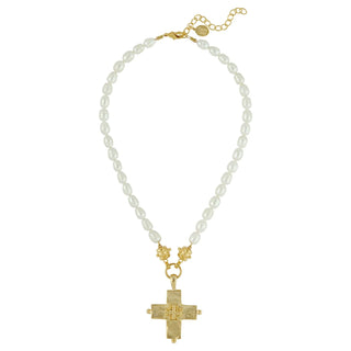 Pearl necklace with a gold cross pendant on a white background