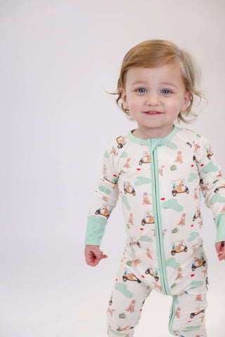 Child wearing a patterned onesie with a white background