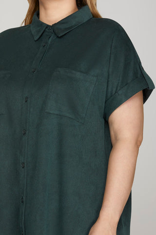 Dark green shirt worn by a person on a plain background