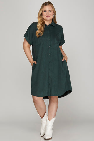 Woman wearing a dark green dress with short sleeves on a gray background