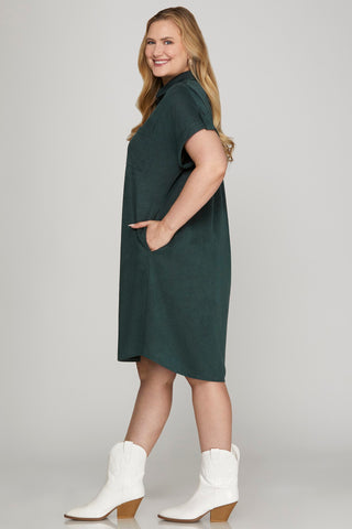 Woman wearing a green dress and white boots on a gray background