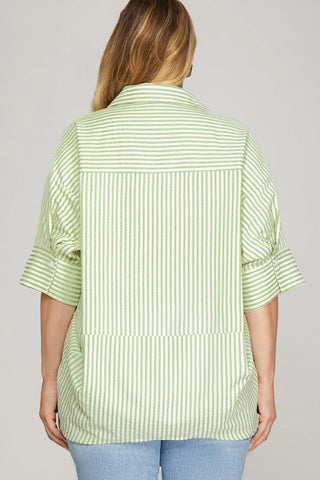 Person wearing a green and white striped shirt against a gray background