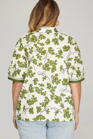 Person wearing a green floral patterned shirt against a plain background