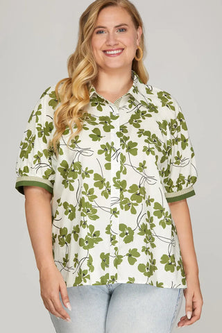 Woman wearing a green floral patterned shirt on a gray background