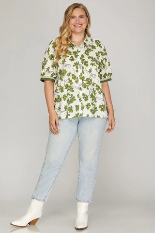 Woman wearing a floral blouse and light blue jeans on a gray background