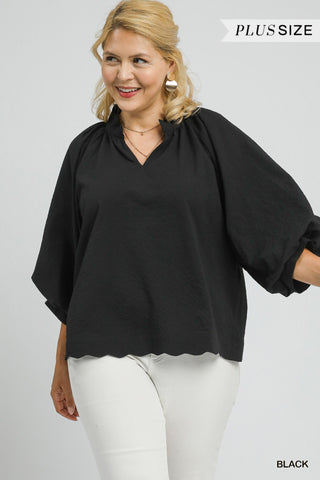 Woman wearing a black blouse with a plain background
