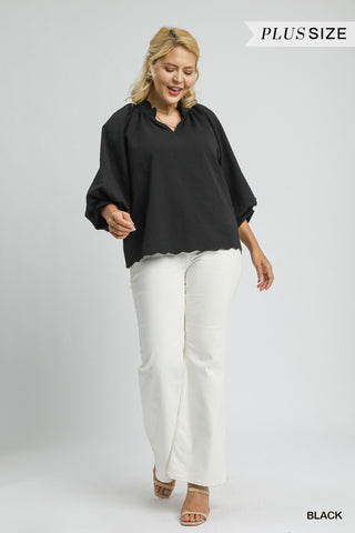 Woman wearing a black blouse and white pants on a gray background