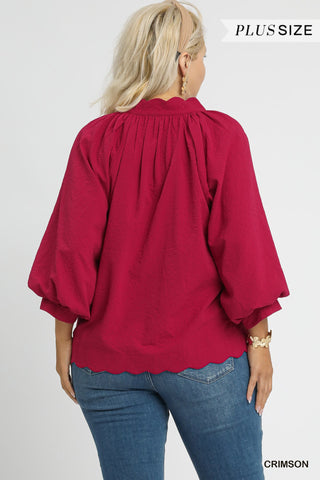 Woman wearing a red blouse with balloon sleeves on a white background