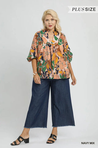 Woman wearing a floral blouse and wide-leg jeans with 'Plus Size' text above.