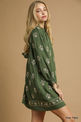 Woman wearing a green dress with floral patterns on a beige background