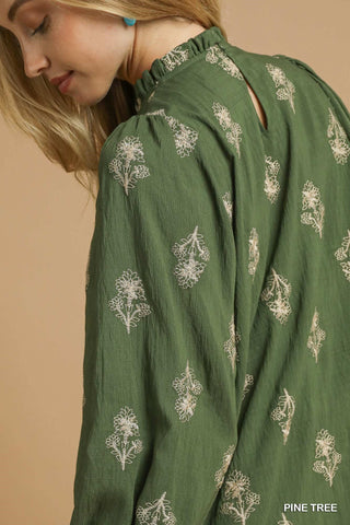 Green dress with floral patterns on a beige background