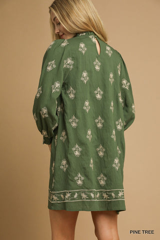 Green patterned dress worn by a person on a beige background