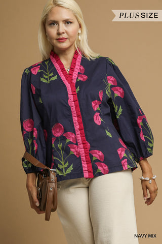 Woman wearing a navy blouse with pink floral patterns on a beige background