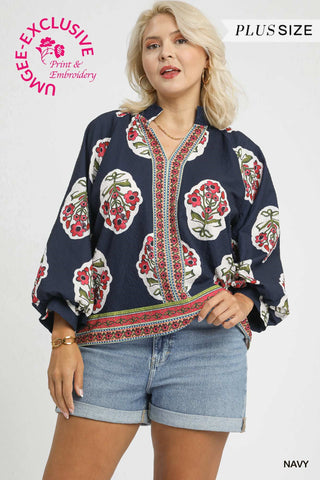 Woman wearing a navy blouse with floral patterns on a white background
