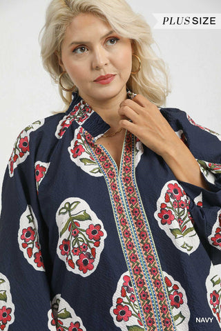 Woman wearing a navy blue blouse with floral patterns on a white background