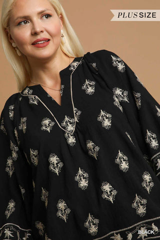 Woman wearing a black floral patterned dress against a beige background