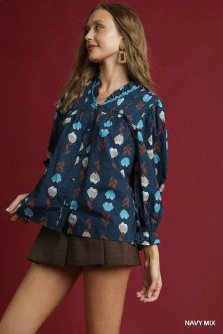 Woman wearing a navy floral blouse against a red background