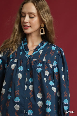 Woman wearing a navy blue blouse with floral pattern against a red background