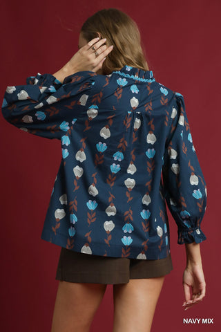 Person wearing a navy floral patterned jacket against a red background