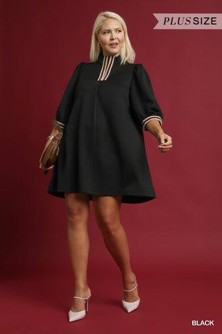 Woman wearing a black dress with gold accents on a red background
