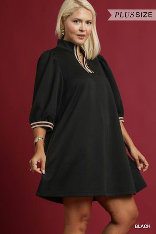 Woman wearing a black dress with white trim on a red background