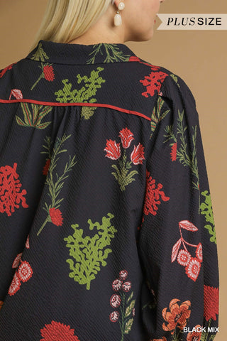 Floral embroidered blouse with red and green details on a black background