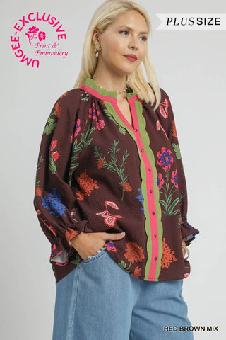 Woman wearing a floral blouse with colorful accents on a plain background