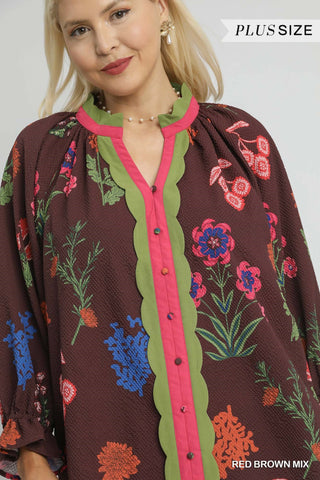 Woman wearing a plus-size floral blouse with a red brown mix color scheme.
