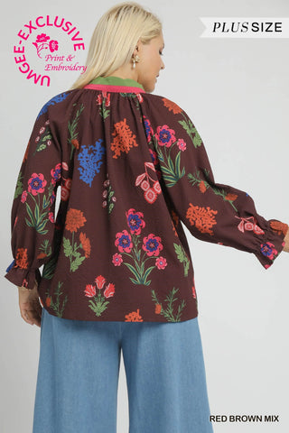 Woman wearing a brown blouse with colorful floral patterns on a gray background